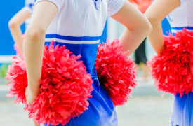 young female cheerleaders holding pom-poms during competitions